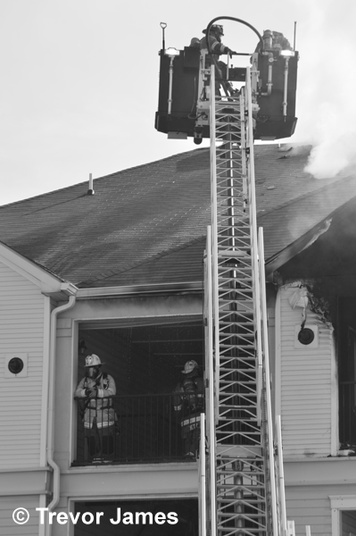 tower ladder in use at townhouse fire