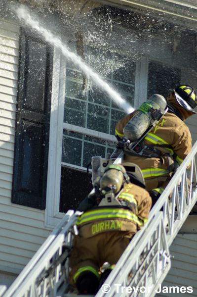 firemen use hose line from aerial ladder