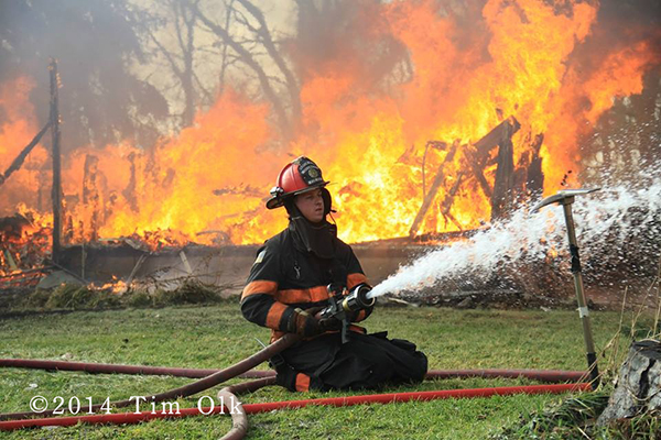 fireman with hose and fire