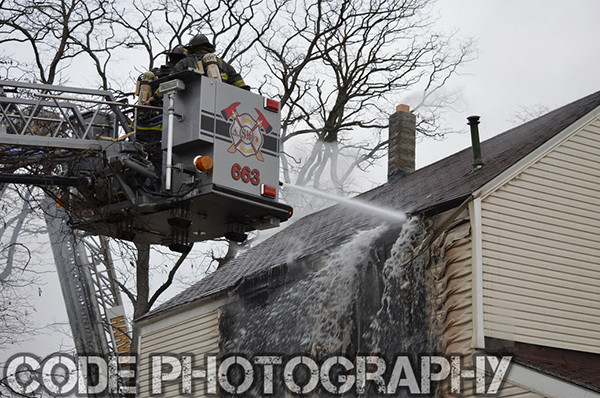 firemen in tower ladder bucket at fire scene