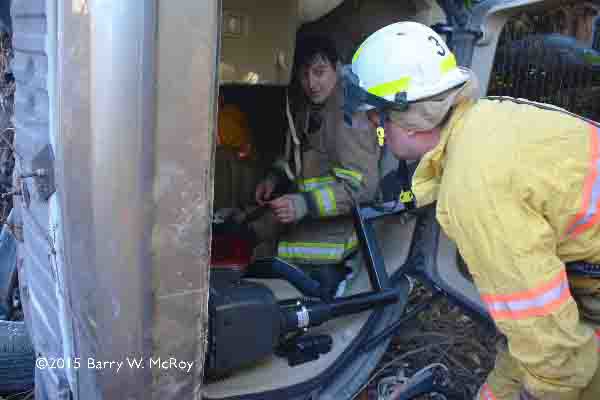 firefighters extricate victims from car