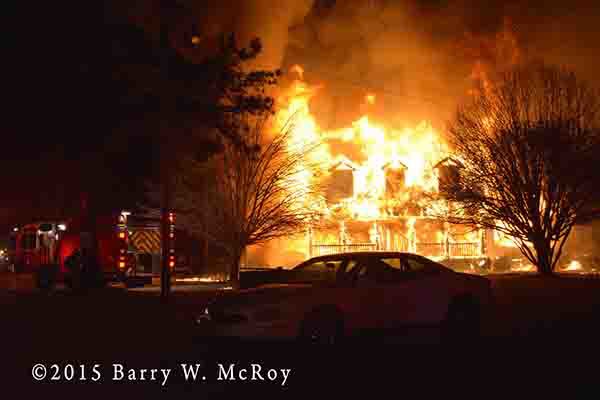 huge house fully engulfed in flames at night