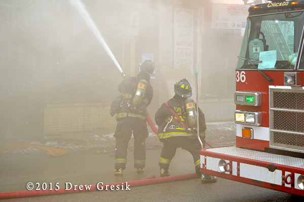 firemen with hose in smoke