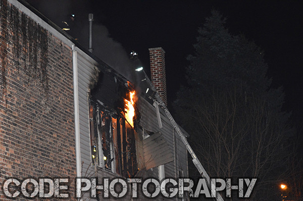 fireman on ladder at night with flames