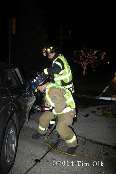firemen cut crash victims from car at night
