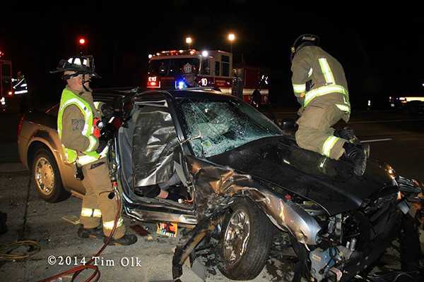 firemen cut crash victims from car at night