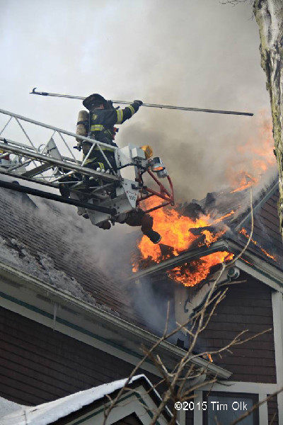 fireman on aerial ladder with heavy smoke and fire