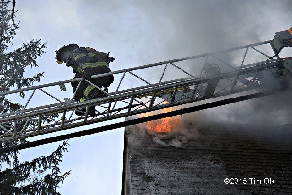 fireman on aerial ladder with heavy smoke and fire
