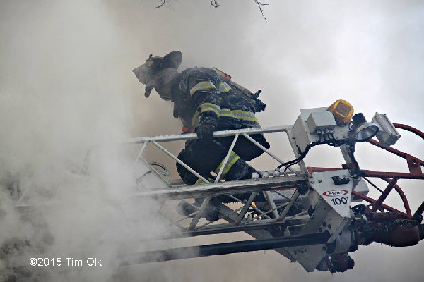fireman on aerial ladder with heavy smoke