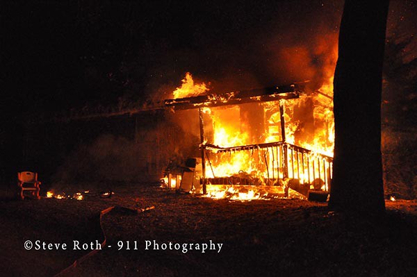 house fully-engulfed in flames at night