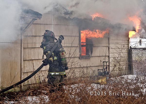 firemen stretch hose at a fire