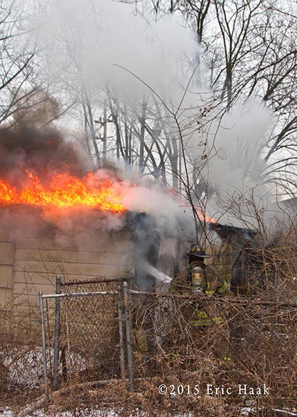 fireman with a hose line battling a fire