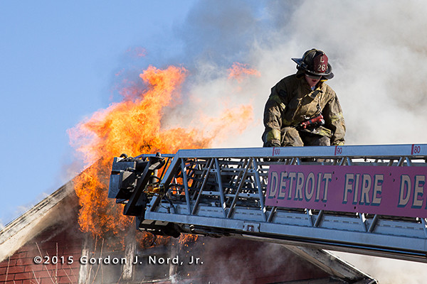 Detroit fireman on a ladder with heavy fire