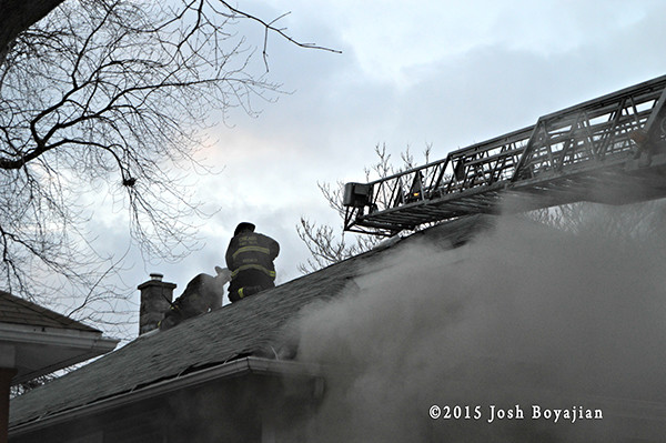 firemen vent roof of house fire