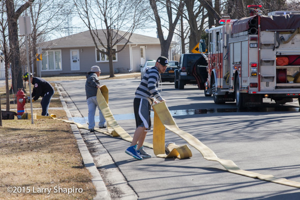 civilians help pull fire hose