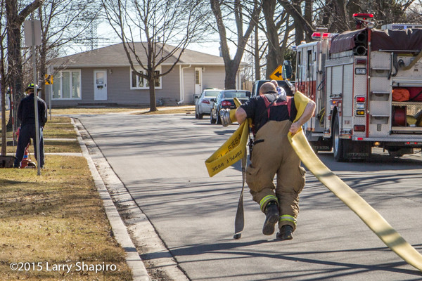 fireman pulls hose towards hydrant