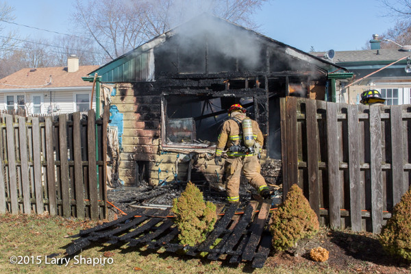 fireman surveys charred garage