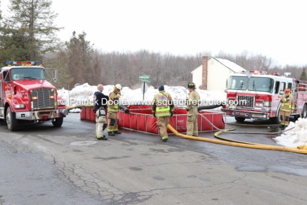 firemen setup portable tank at fire scene for drafting water from tankers