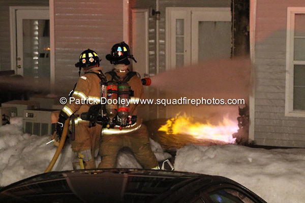 firemen fight flames at a house at night