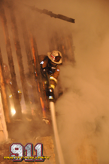 firemen battle a house fire at night