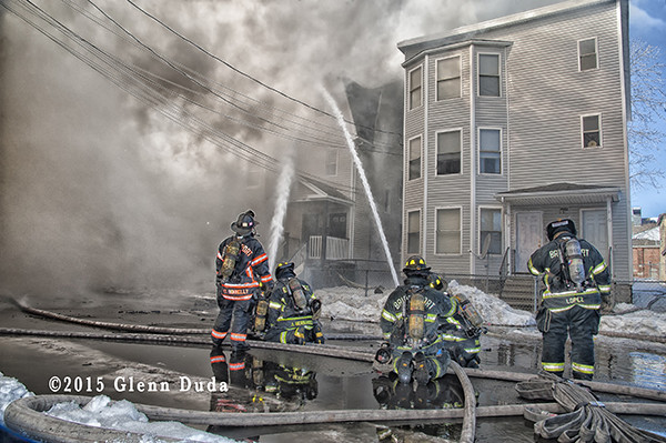 firemen working at a fire scene with heavy smoke