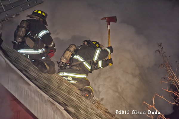 fireman on roof with axe and thick smoke at night