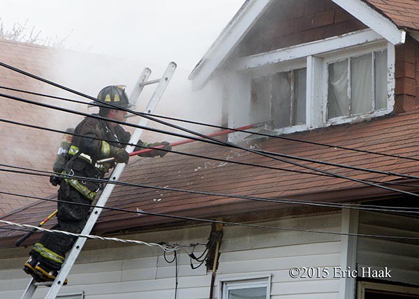 firemen venting window from ladder