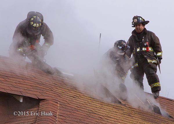 firemen venting roof with smoke