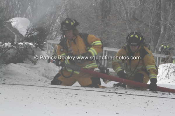 firemen with hose line in the winter
