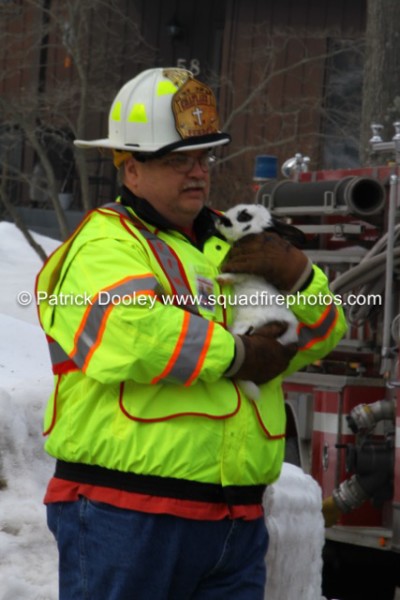 fire department chaplain carries family pet from house fire