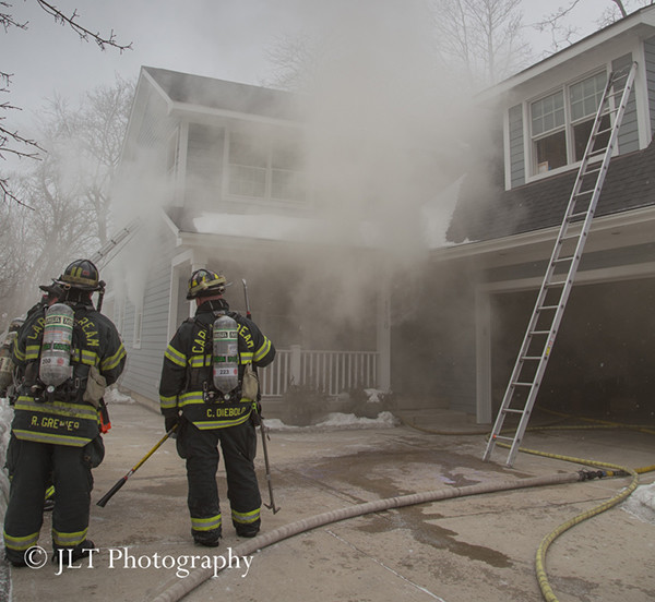 firemen at house fire with heavy smoke