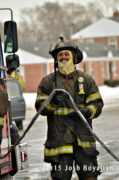 soaking wet fireman picks up  hose