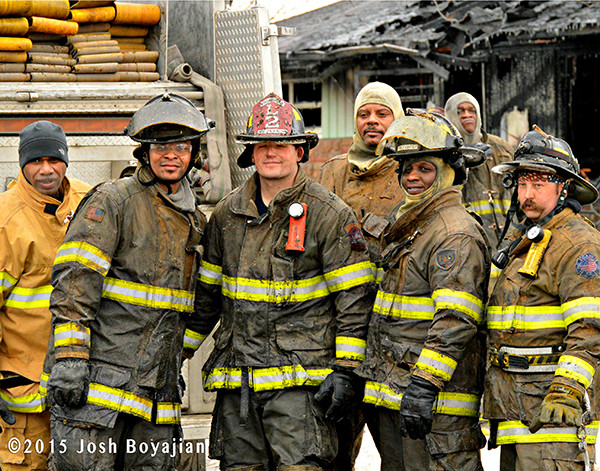 firemen pose after fighting a fire