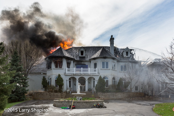 mansion on fire with heavy smoke and flames