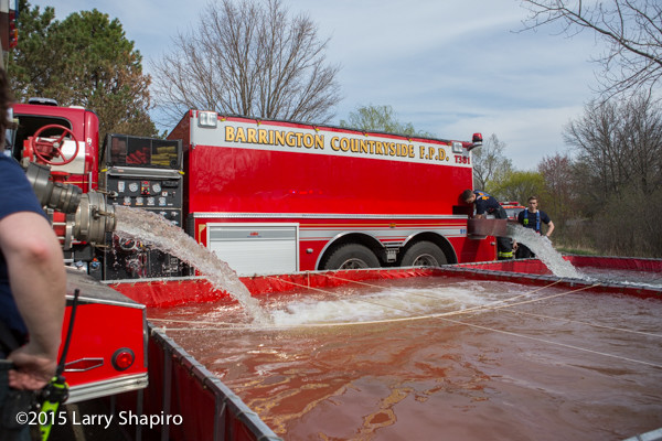 fire department water tenders dump into portable tanks