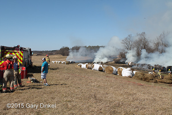 hundreds off rolled hay bales burn in a field