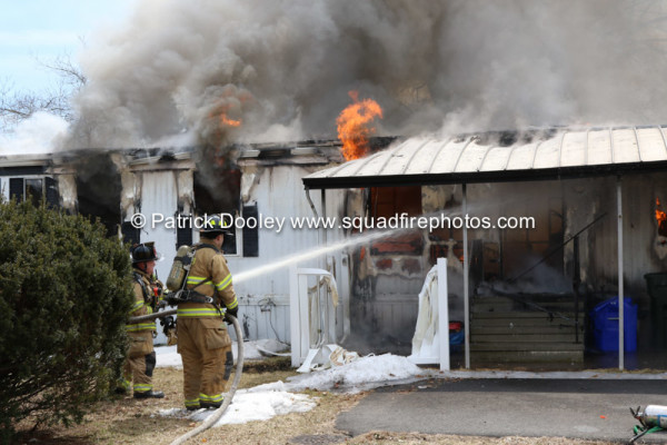 firemen battle a mobile home fire