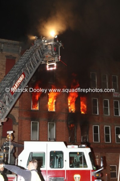 Sutphen tower ladder working at apartment building fire with flames shooting out