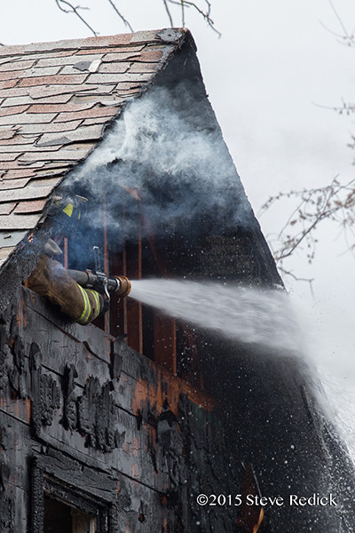 fireman hitting hot spots after house fire