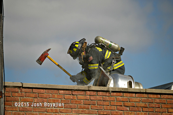 fireman on roof with an axe