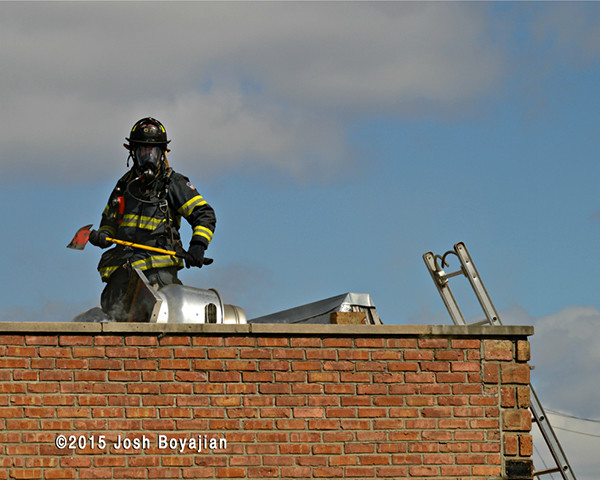 fireman on flat roof with axe