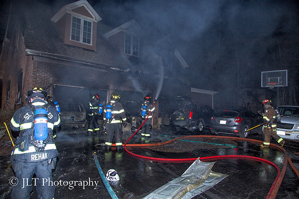 firemen with hose line at night fire scene