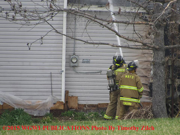firemen with hose line at house fire