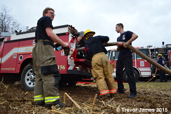 firemen add water to a fire departmetn brush truck