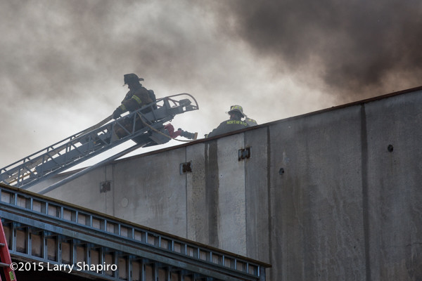 fireman on aerial ladder with dark smoke