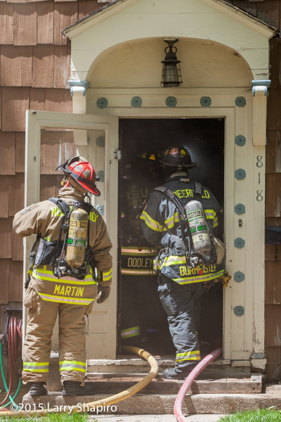 firemen enter house during fire