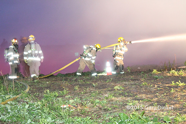 firemen with hose line at night