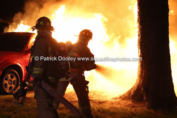 silhouette of firemen with hose at night