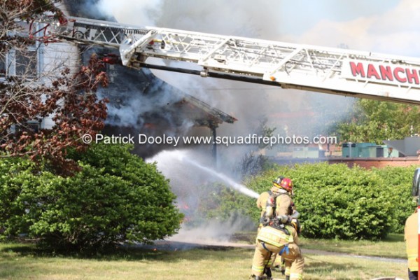 fireman with hose battles house fire