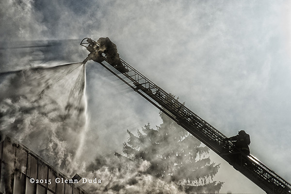 fireman works from the tip of an aerial ladder